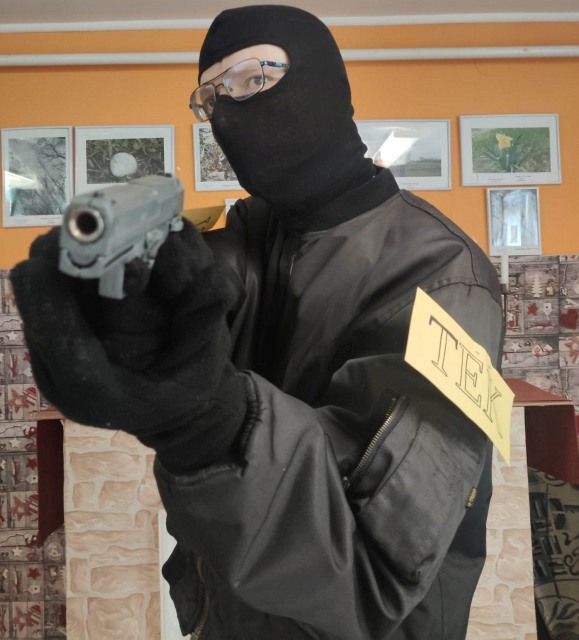 TEK-esnek öltözött lakó fegyverrel céloz a kamerába